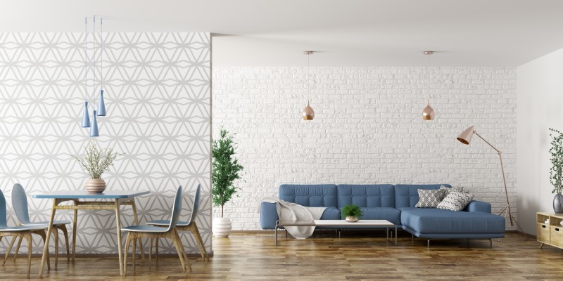 Modern eingerichtetes Wohnzimmer mit blauer Couch, gemusterter Tapete und Essbereich.